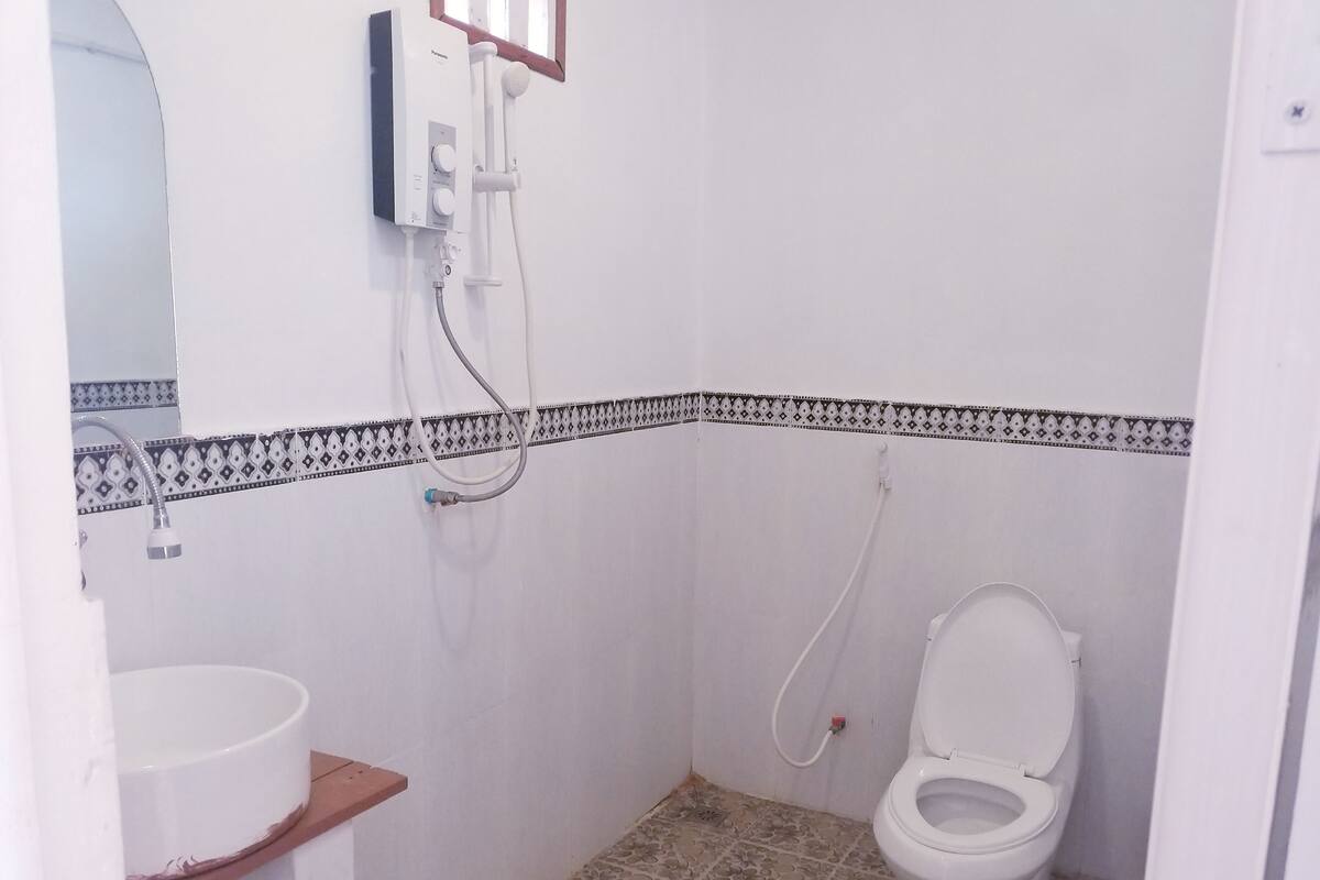 A small bathroom with a toilet, a sink, and a shower.