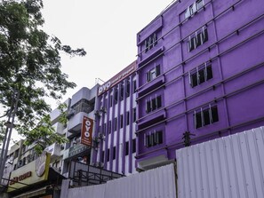 A multi-story hotel with a purple facade, balconies, and signage for 'Oyo Hotel D'Elegant' and 'Oloiya'.
