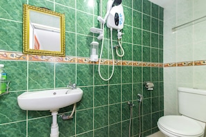 A bathroom with a white sink, a mirror with a gold frame, a hairdryer, and a toilet.