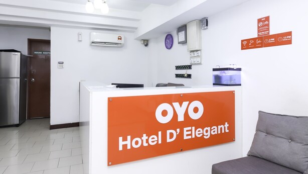 A reception desk with a sign reading "OYO Hotel D'Elegant".
