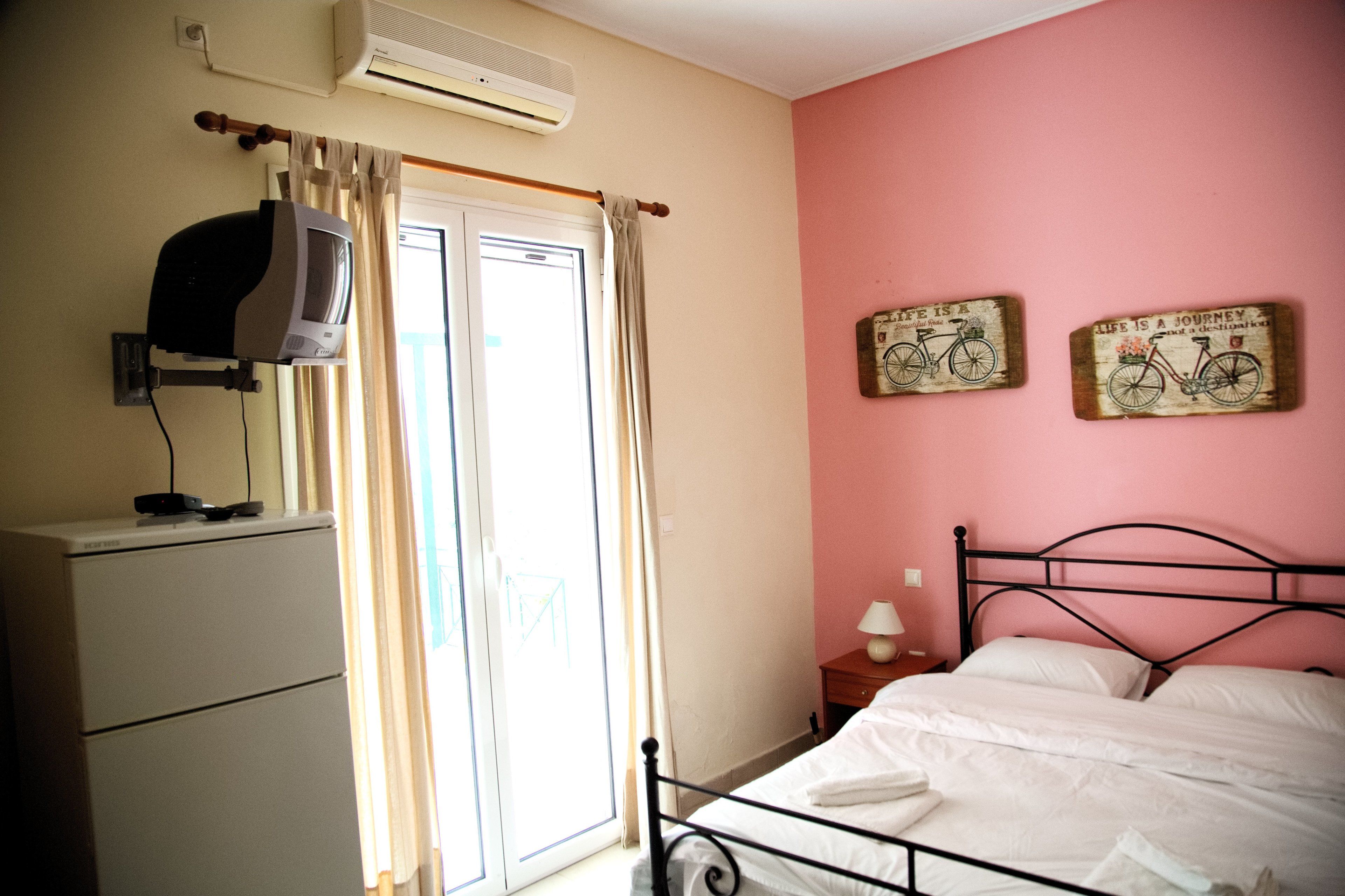 Une chambre à coucher comprenant un lit, une commode, un climatiseur et deux panneaux fixés au mur.