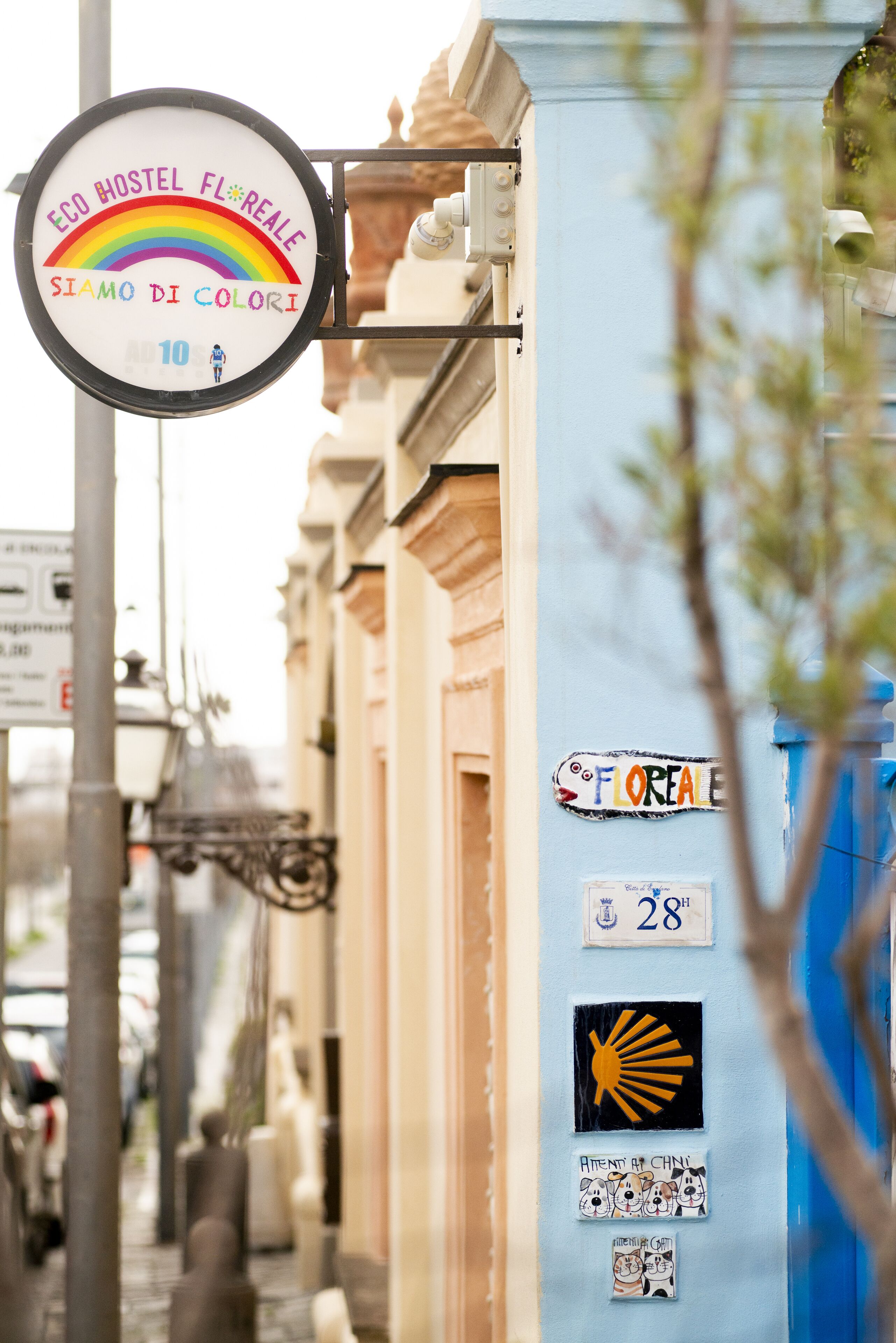 Un letrero de hostal con un arcoíris y el texto "ECO HOSTEL FLOREALE SIAMO DI COLORI".