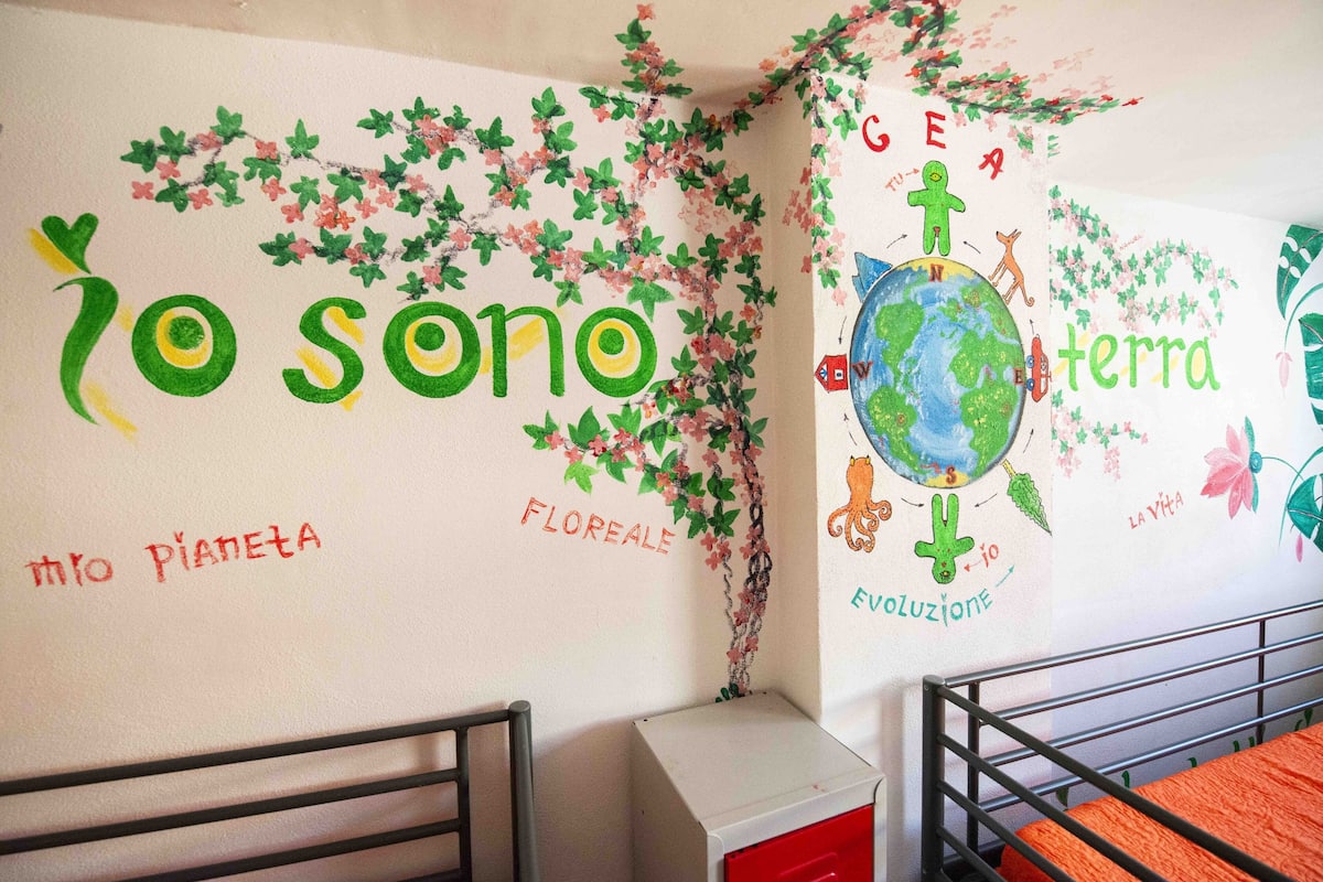 Una pared infantil con dibujos y texto educativo sobre el medio ambiente.