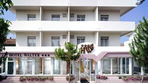 Un hôtel à plusieurs étages au design moderne, avec une enseigne bien visible ornée d’étoiles et d’un logo.