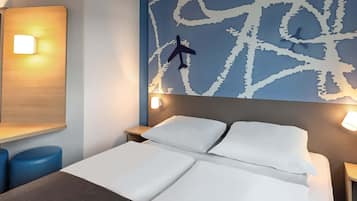 A hotel room with a bed, two bedside tables, a nightstand, and a wall with a map design.