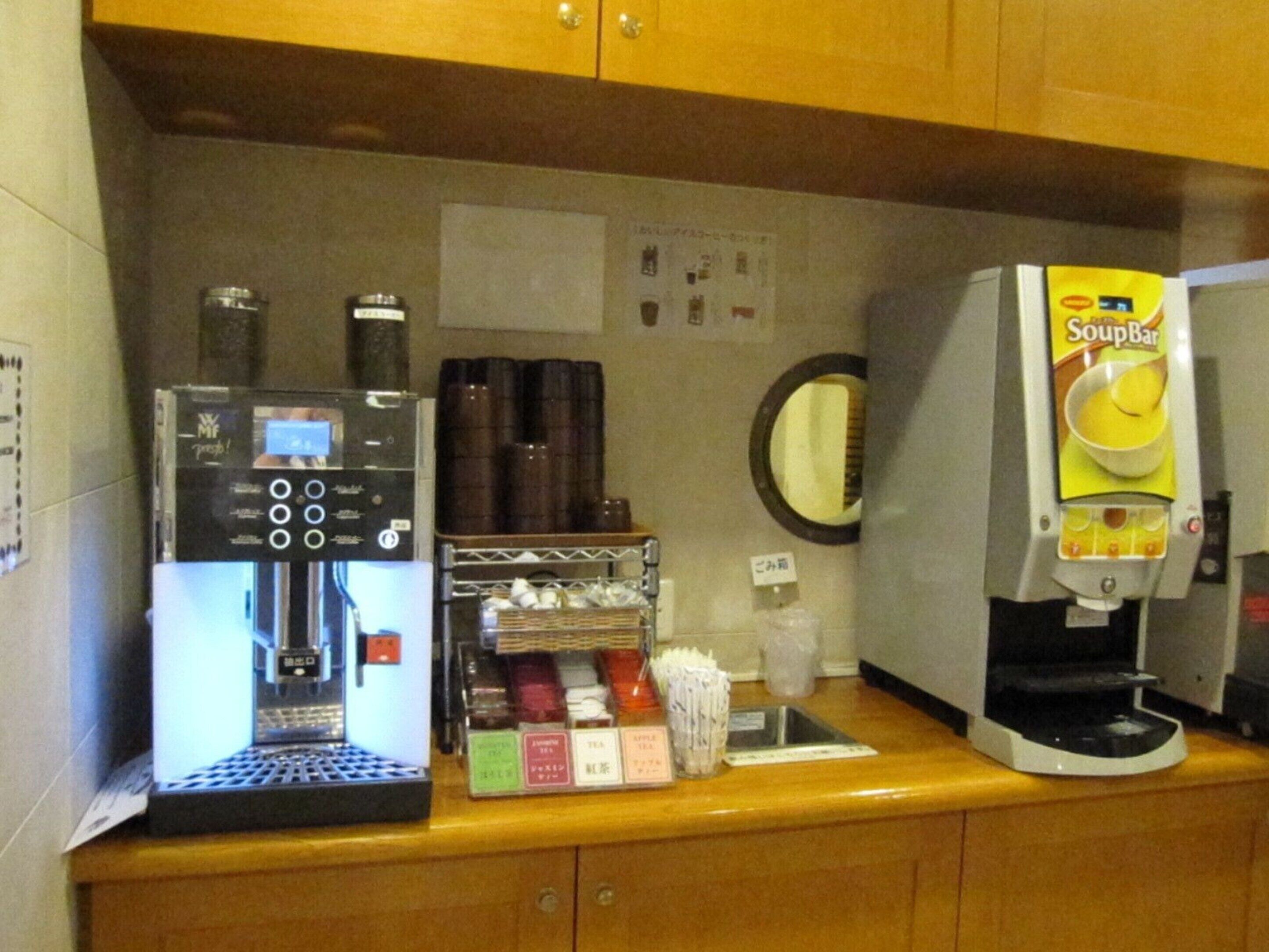 A coffee machine, a soup dispenser, and a small refrigerator on a counter.