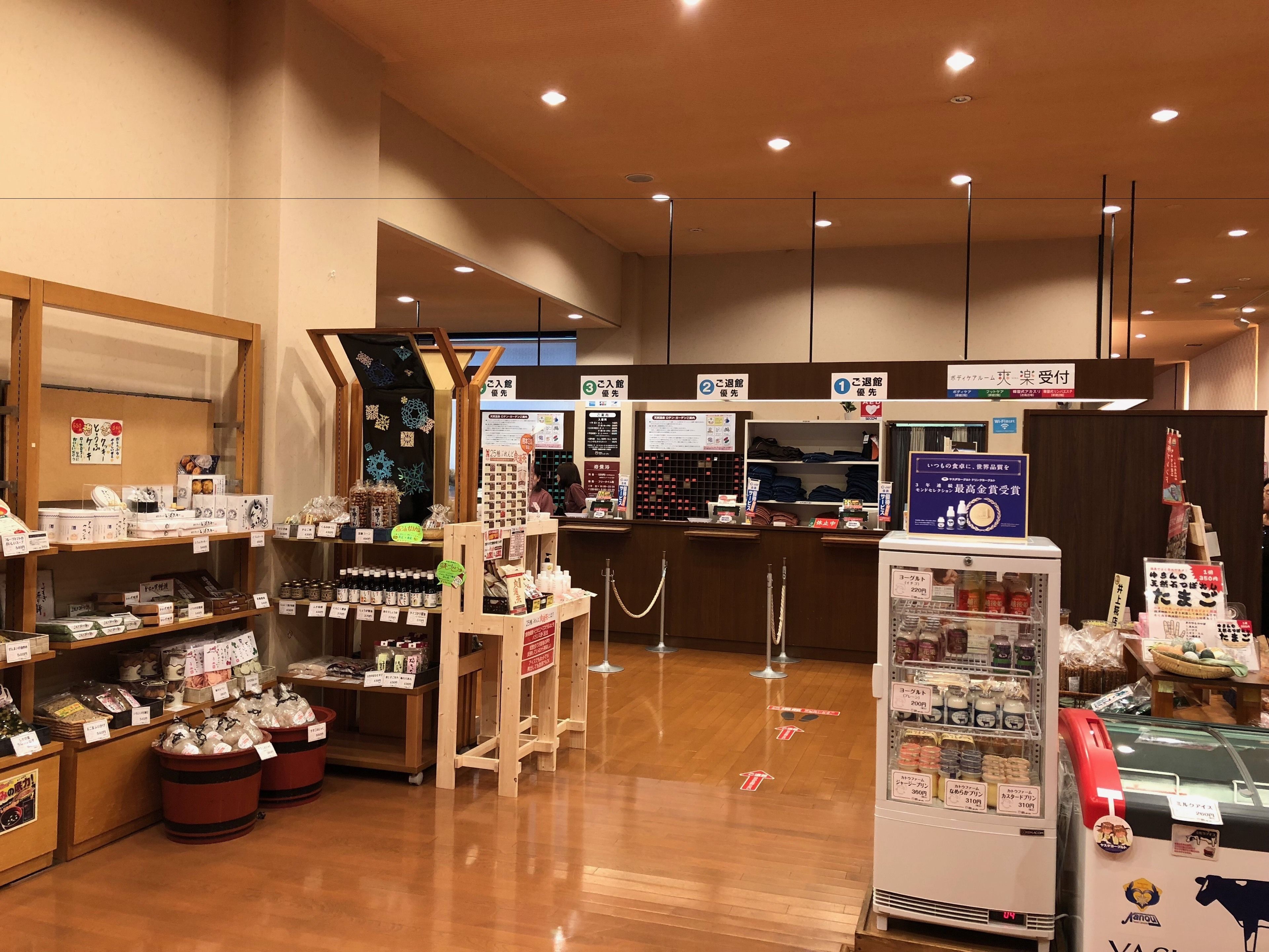 A Japanese convenience store with wooden counters, refrigerated sections, and various packaged goods.