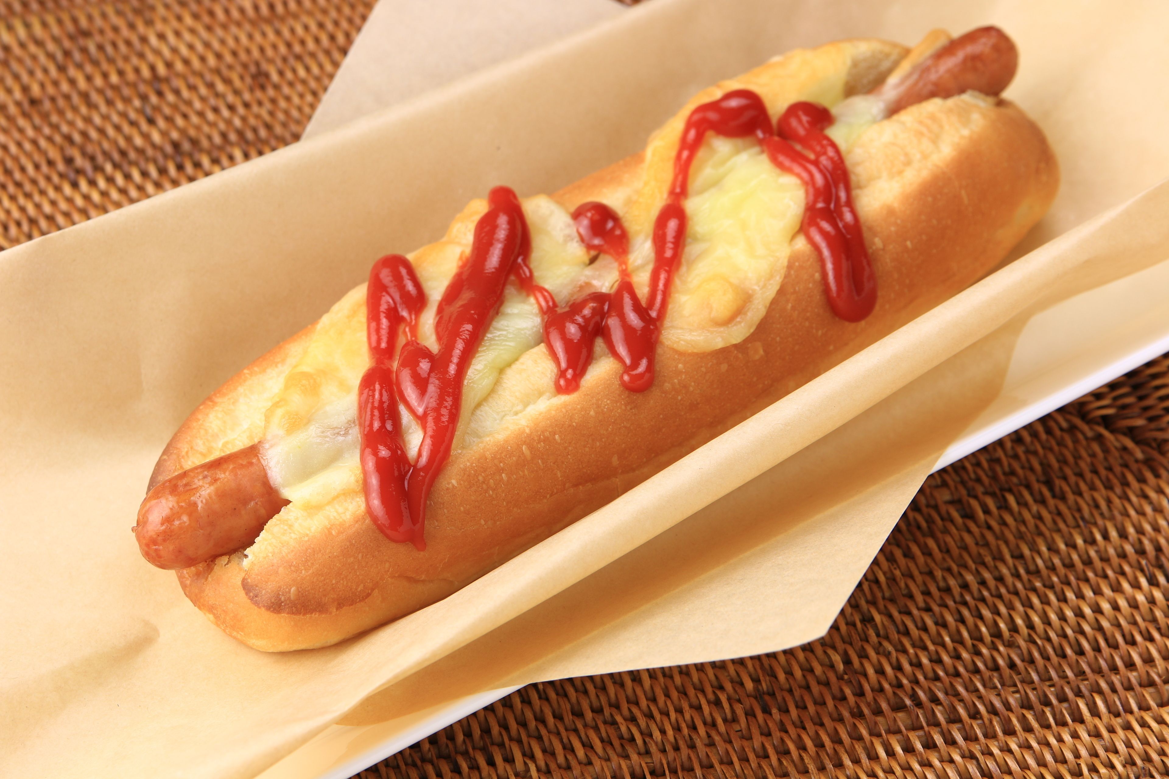 A hot dog in a bun with ketchup and mustard.