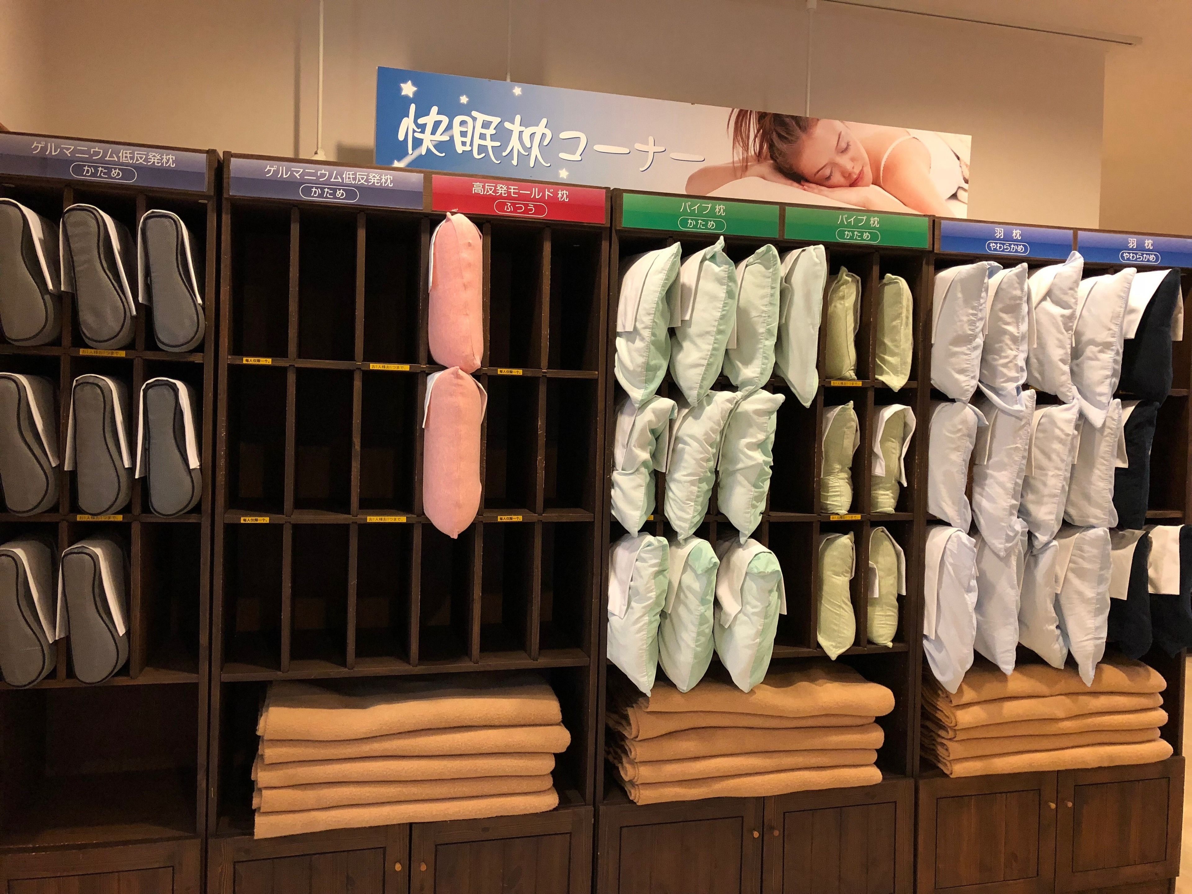 A store with shelves of pillows and folded blankets.