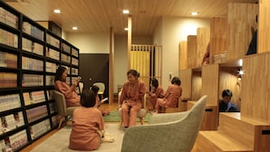 A library with bookshelves, seating areas, and wooden partitions. - Laxio-Inn (Machida)