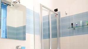 A bathroom with a sink, mirror, shower, and bidet. - Villa Marogna Rooms and Breakfast (Alghero)