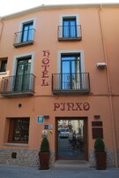 Un hotel llamado "HOTEL PUNXO" con balcones, un bar y una entrada visible.
