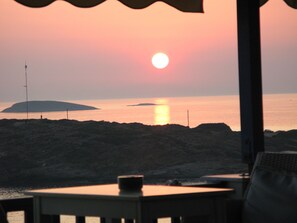 Relax in a serene coastal setting with a tranquil ocean view, a natural shoreline, and a covered seating area perfect for dining or unwinding.