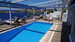 Relax by the pool with a view of the sea and distant coastline.