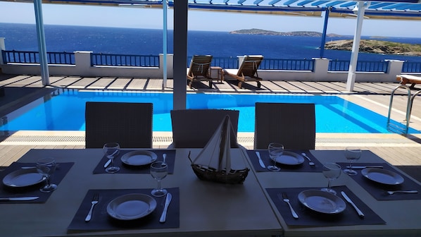 Enjoy meals with a view of the sea and distant land from this dining area.