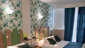 Habitación de hotel con dos camas, una mesita, una lámpara y un radiador.