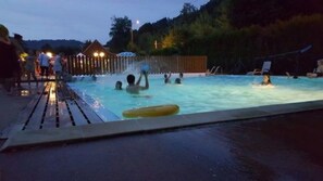En säsongsöppen utomhuspool, parasoller och solstolar