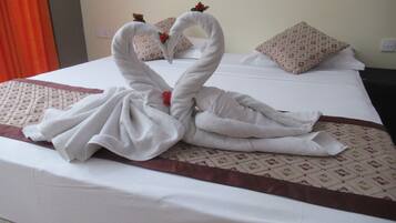 Habitación de hotel con cama y un centro de mesa decorativo con forma de cisne de toalla.