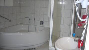 Un baño con bañera, ducha y lavamanos.