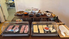 A buffet setup with various food items and condiments.