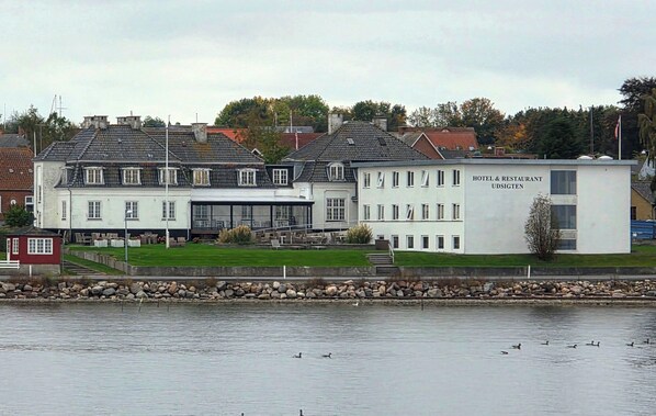A hotel with a modern building and a traditional building across the water.