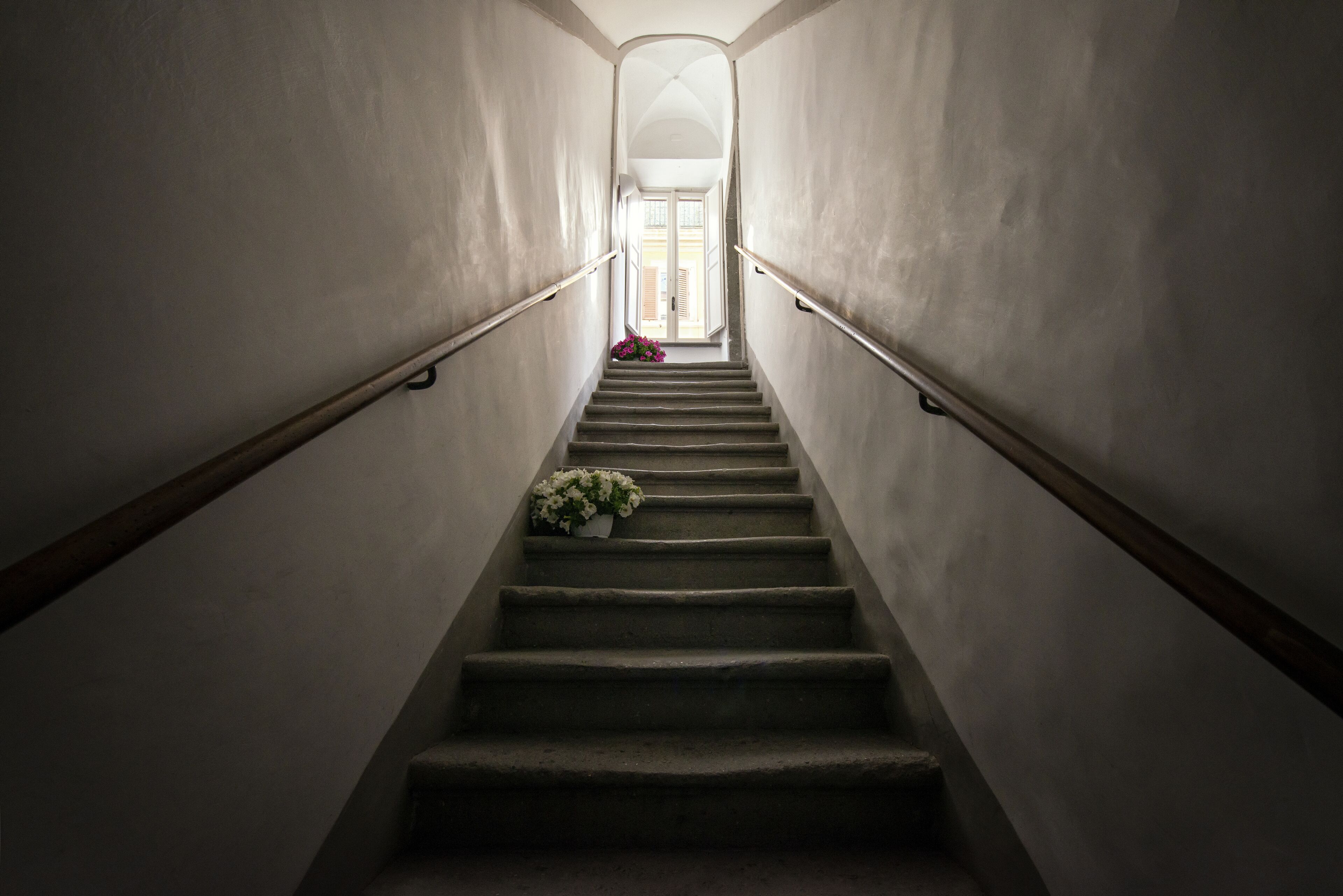 Un escalier doté d’une rampe, menant à un espace intérieur lumineux.
