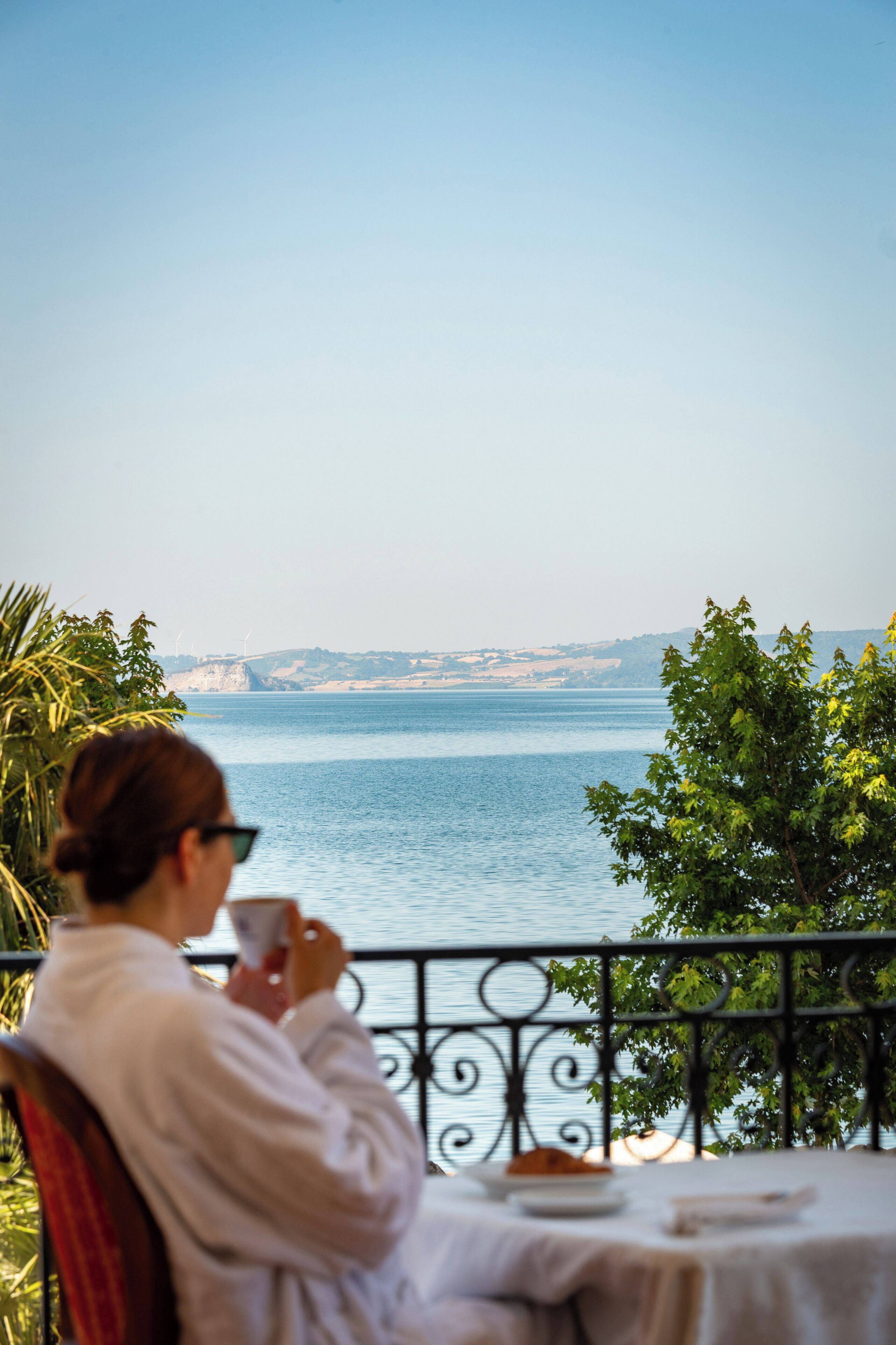 A person sitting at a table with a view of the sea.