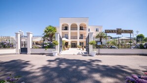 A hotel entrance with a gated driveway, a central entrance, and a sign reading "HOTEL HOLIDAS". - Hotel Holiday (Bolsena)