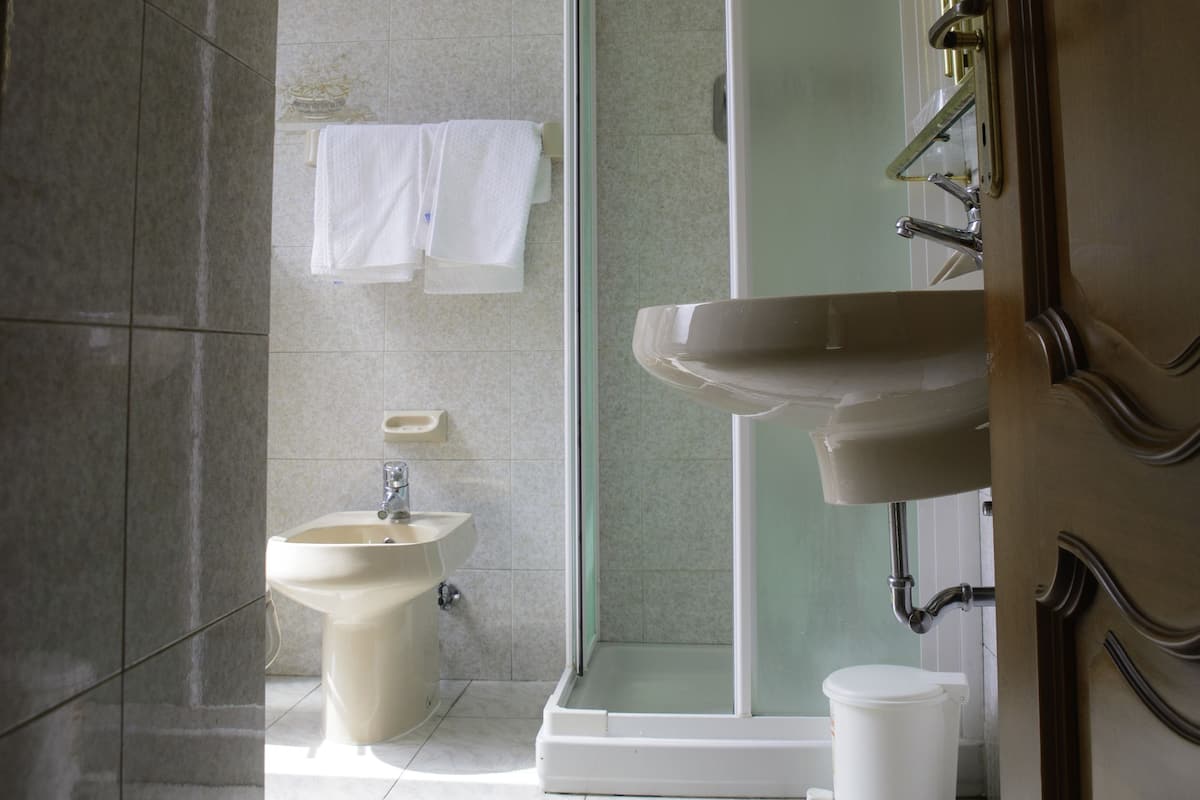 A bathroom with a shower, sink, and toilet.