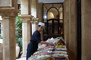 Un bufé con diferentes alimentos y una persona atendiendo.