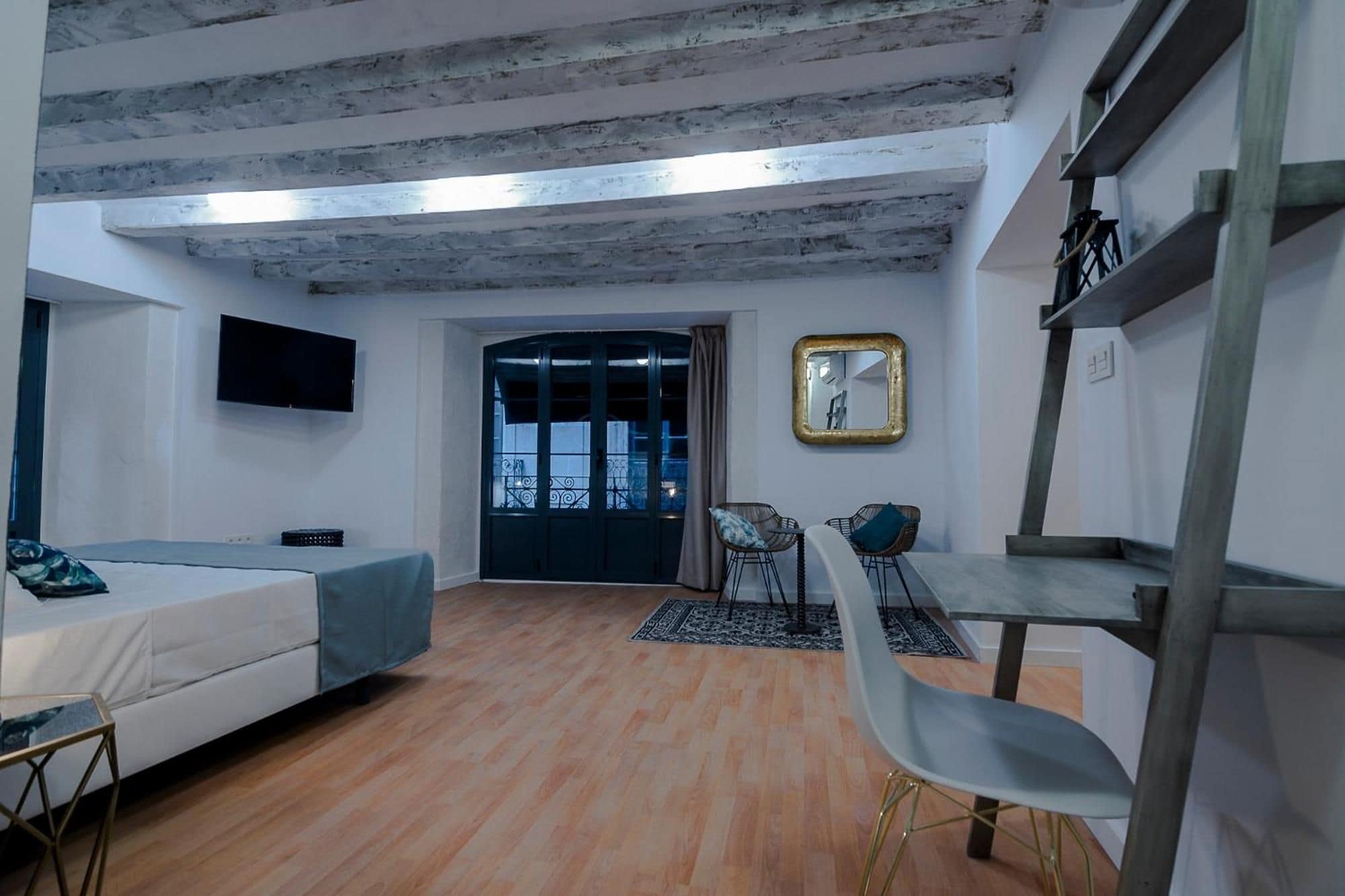Una habitación moderna con sofá, mesa de comedor y televisor montado en la pared.