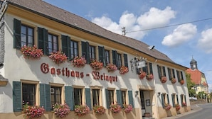A building with a sign reading 'Gasthof - Weingut' and flower boxes on the windows. - Weinhaus Hehner Kiltz (Waldböckelheim)