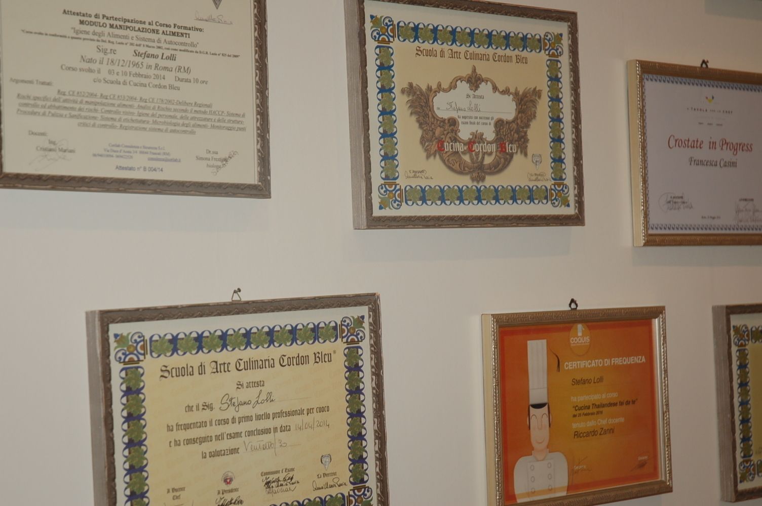 A wall displaying various framed certificates and awards.