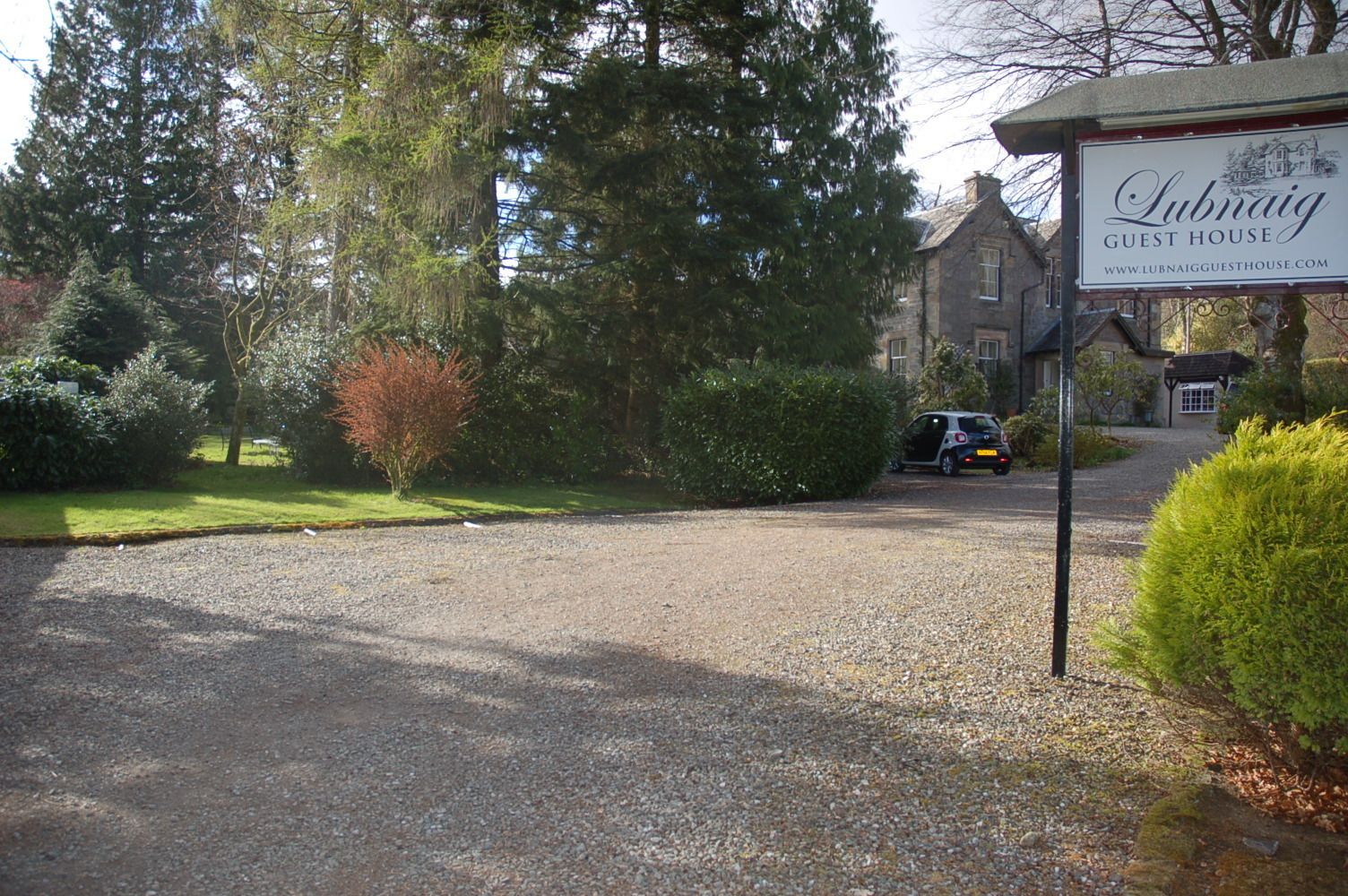 A gravel driveway leading to a guest house named 'Lubnaig'.