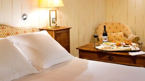 Une chambre d’hôtel avec un lit, une table de chevet avec une lampe, une chaise et un plateau contenant des articles pour le petit-déjeuner.