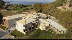 En modern villa med flera rum, en täckt uteplats och utsikt över havet.