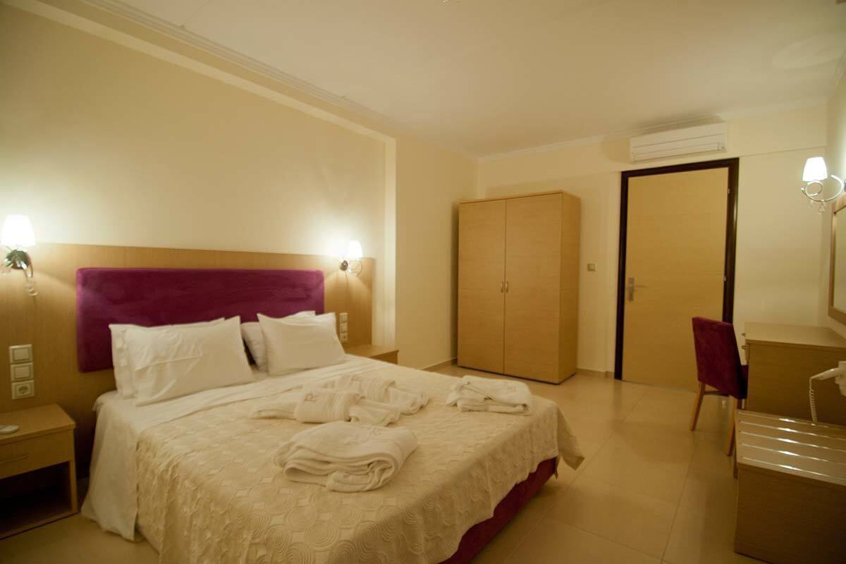 Una habitación de hotel con cama, armario, escritorio y silla.