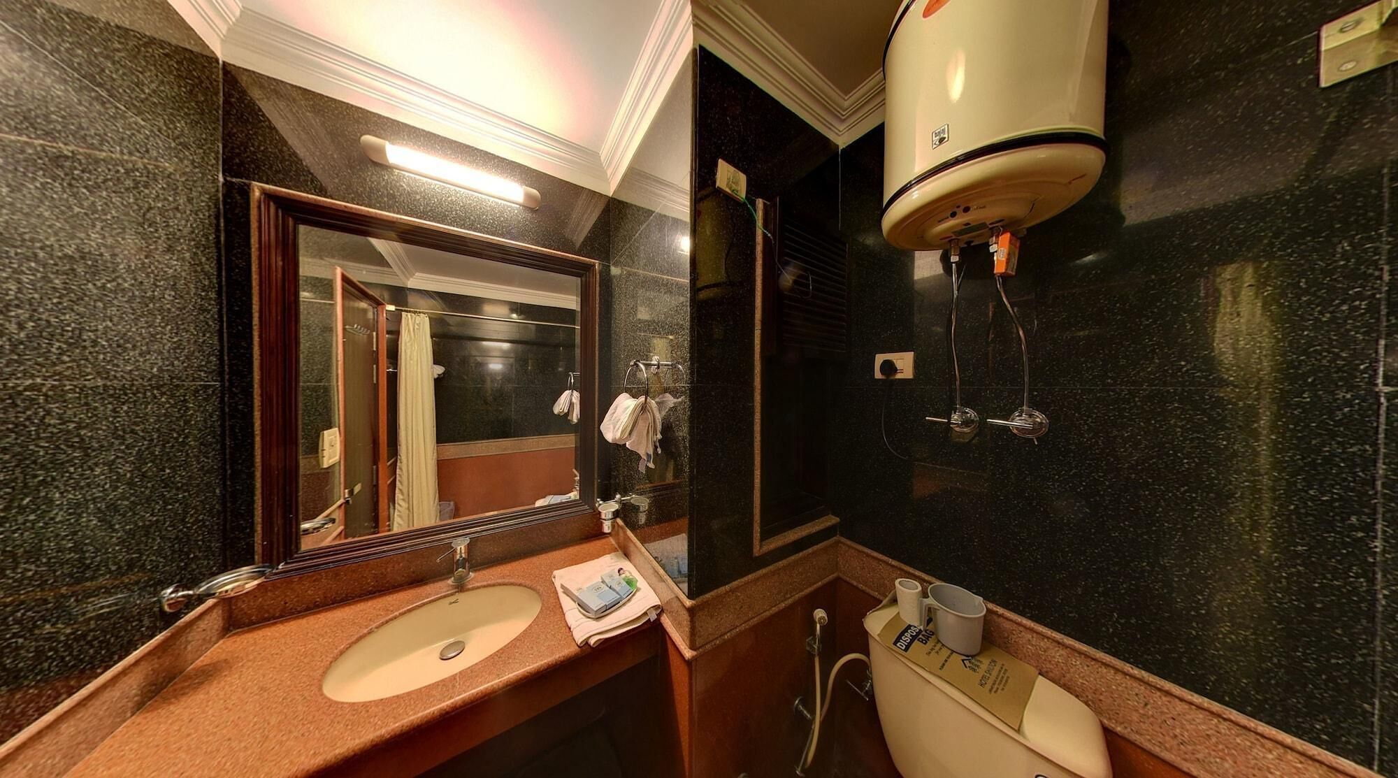 A modern bathroom with a marble countertop, a sink, a mirror, a towel rack, and a heated towel rail.