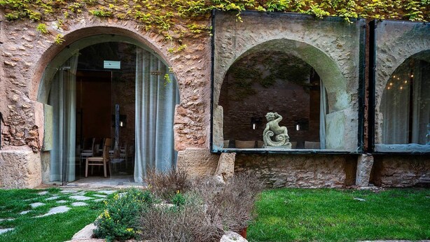 A stone building with arched windows and a statue in one of the windows. - Hotel Castillo de Pilas Bonas (Manzanares)