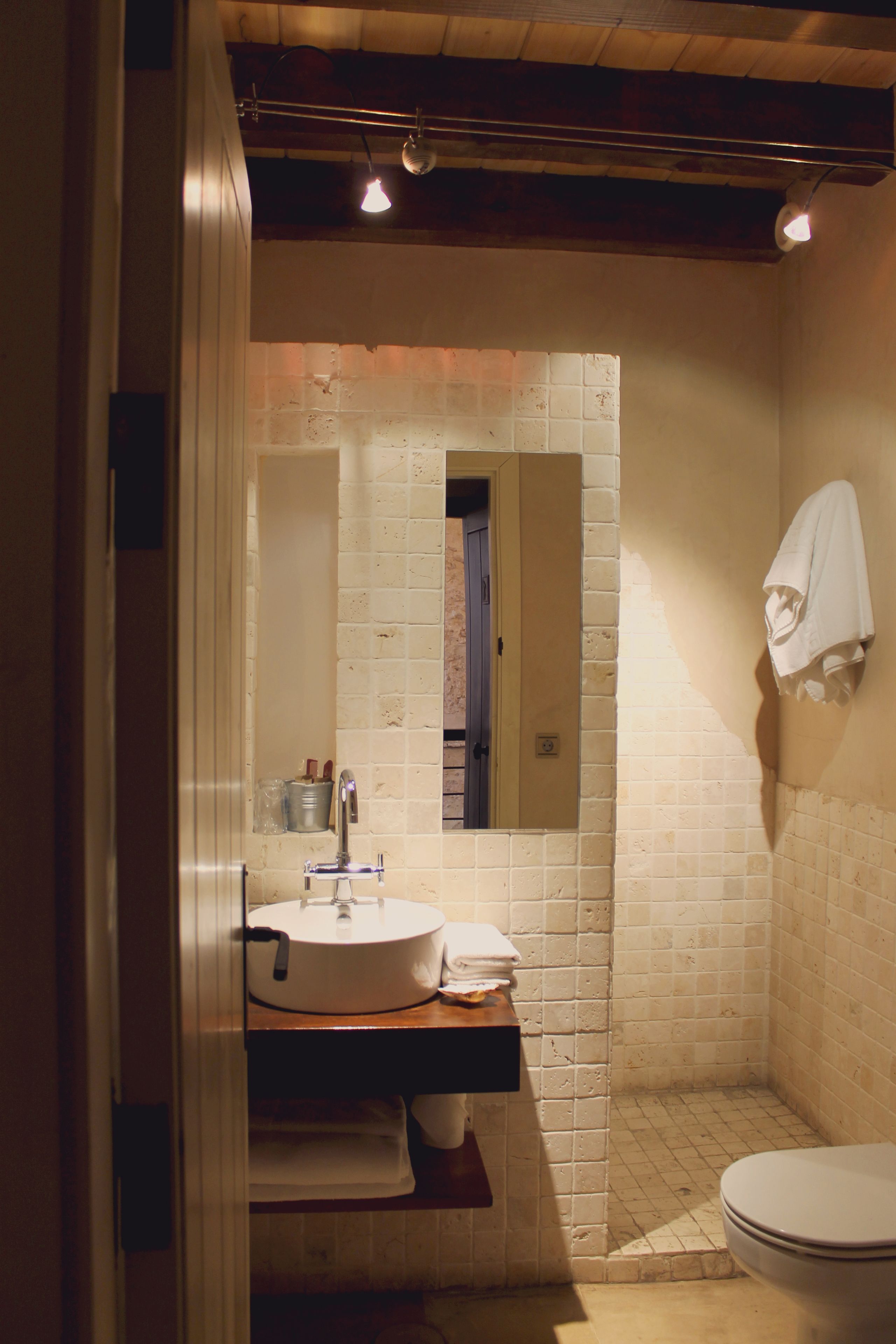Une salle de bain avec un lavabo blanc, un miroir et des toilettes.