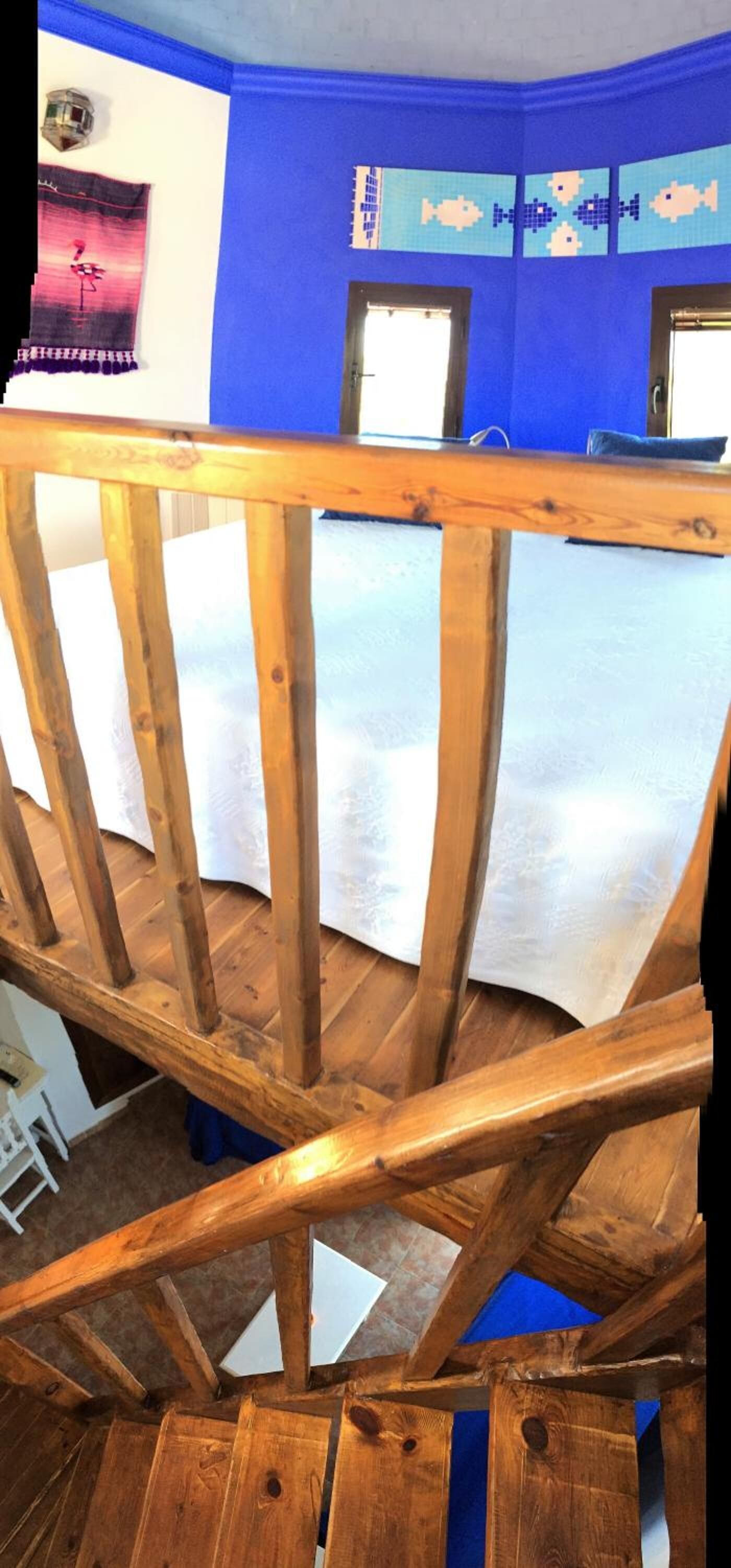 Una scala in legno con una parete blu sullo sfondo.