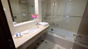 Un baño moderno con ducha de vidrio, lavamanos doble y un espejo grande.