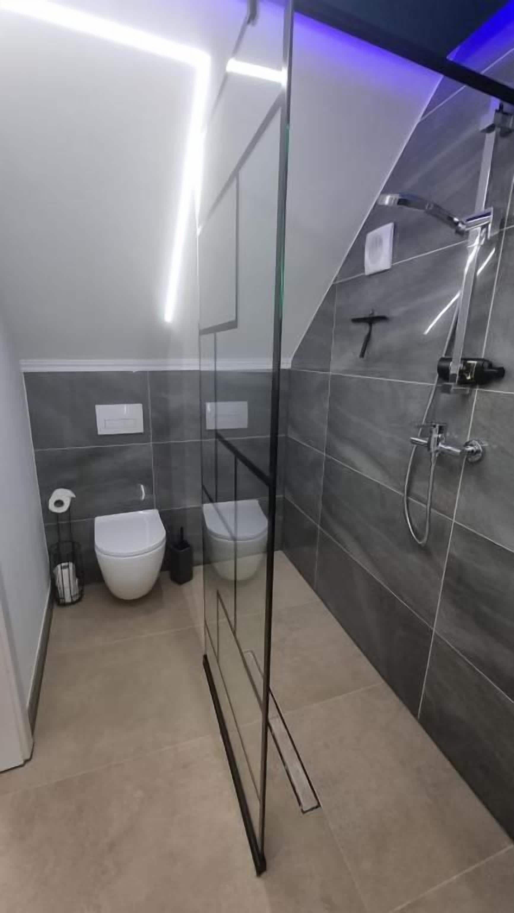 Ein modernes Badezimmer mit Duschkabine aus Glas, Toilette und Bidet.