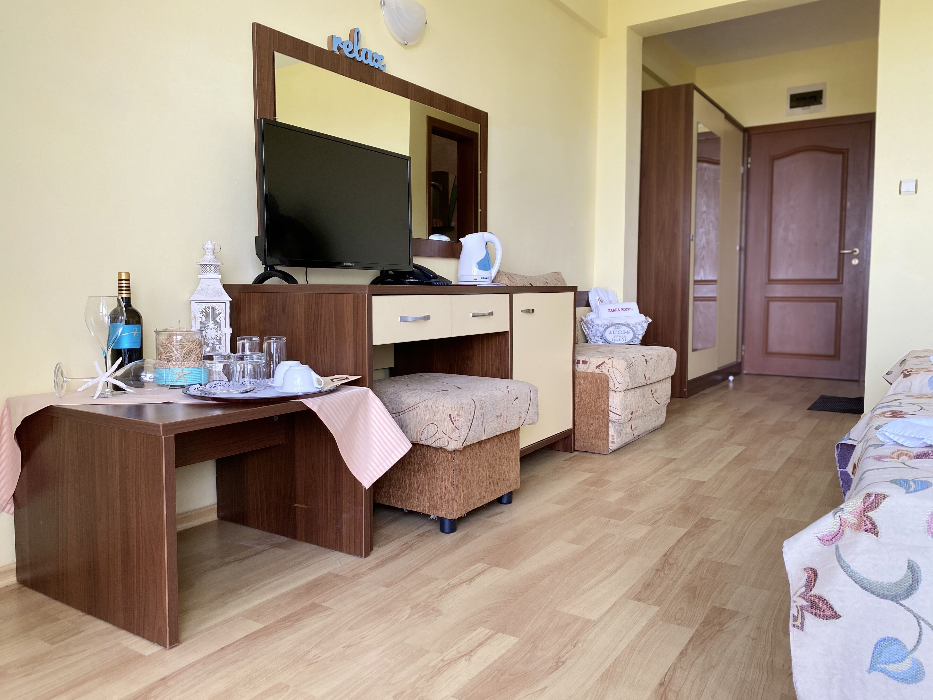 Una habitación de hotel con un escritorio de madera, televisor, sofá y cama.