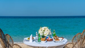 A table set for a meal with a view of the ocean. - Regency Sealine Camp (Mesaieed)