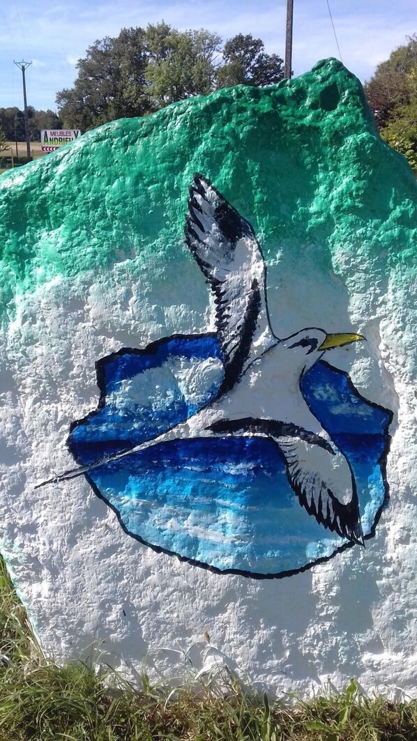 Un cisne pintado sobre una superficie verde.