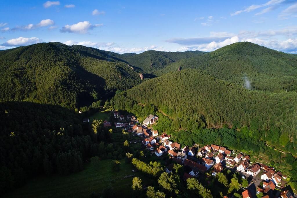 Un pueblo ubicado en un valle rodeado de colinas boscosas.