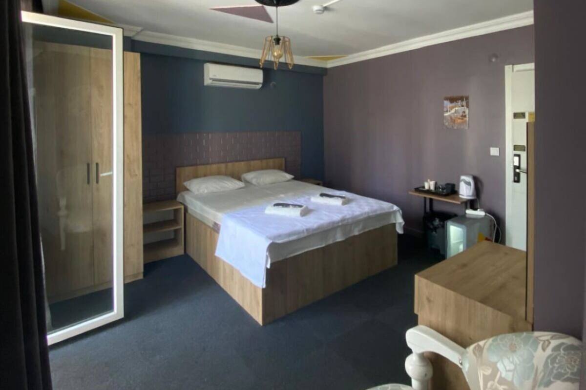 Een slaapkamer met een bed, een bureau, een stoel en een kledingkast.