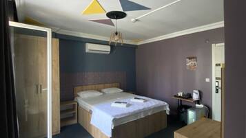 A bedroom with a bed, a desk, a chair, and a wardrobe.
