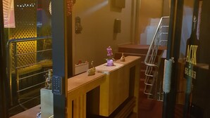 A retro-themed hotel lobby with a wooden reception desk, a wall clock, and a staircase. - Retro Suites (Istanbul)